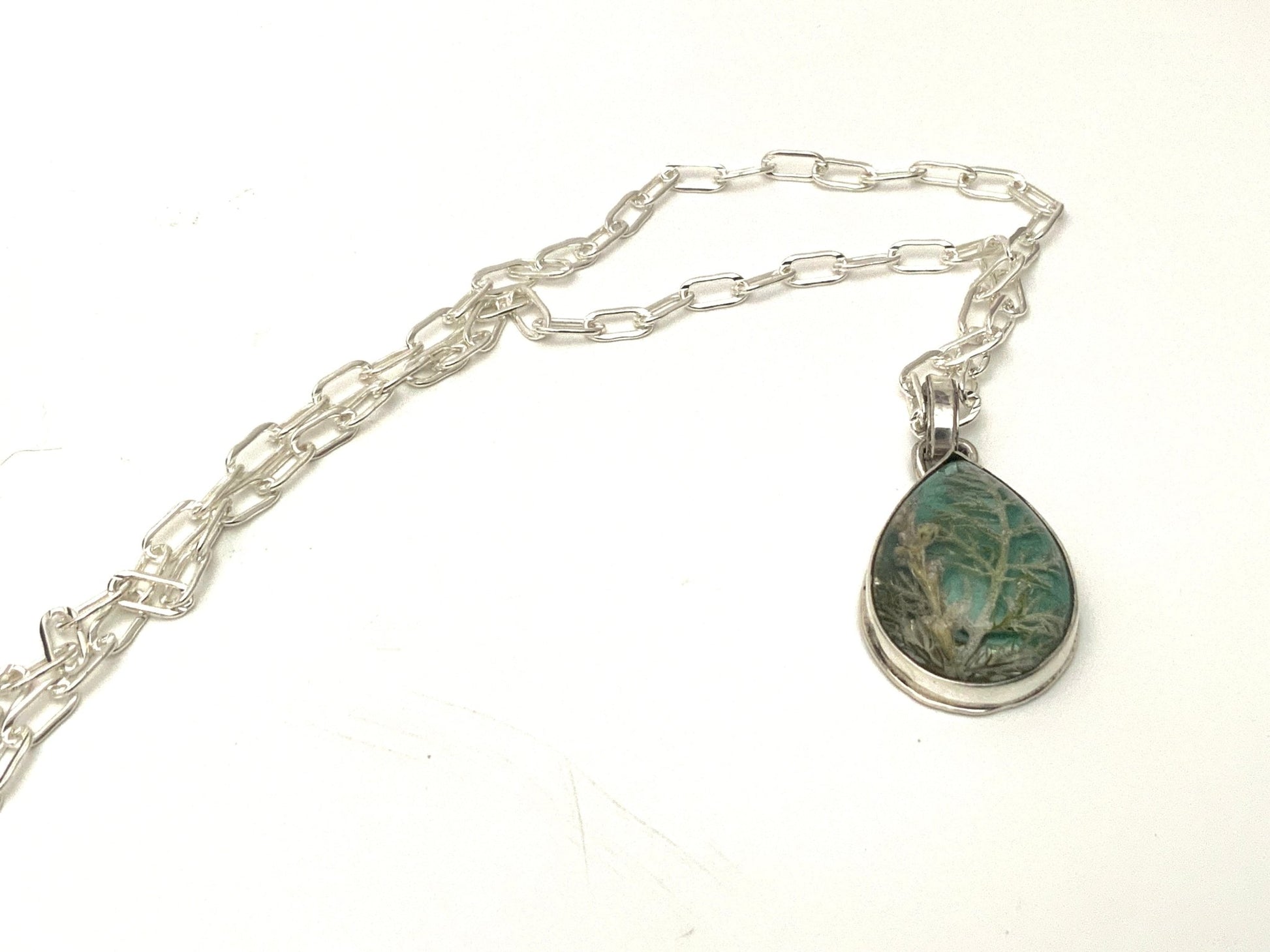 Nature-inspired silver resin cabochon necklace with magnified pressed flowers